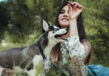 Genç ve güzel kız sevimli köpeğiyle oynuyor. 