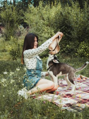 Young beautiful girl playing with her cute husky dog pet 