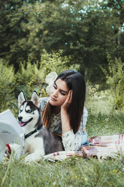 Genç ve güzel kız sevimli köpeğiyle oynuyor. 
