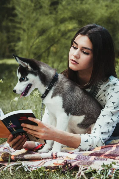 Genç ve güzel kız sevimli köpeğiyle oynuyor. 