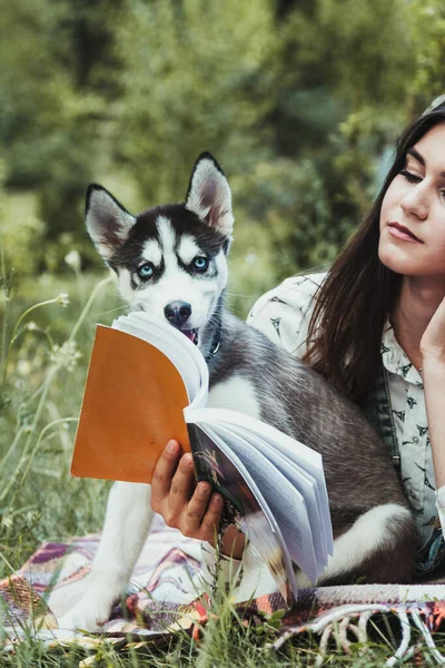 Genç ve güzel kız sevimli köpeğiyle oynuyor. 