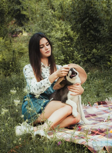 Genç ve güzel kız sevimli köpeğiyle oynuyor. 