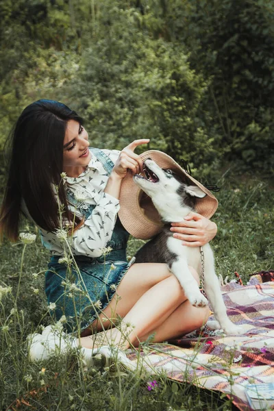 Genç ve güzel kız sevimli köpeğiyle oynuyor. 