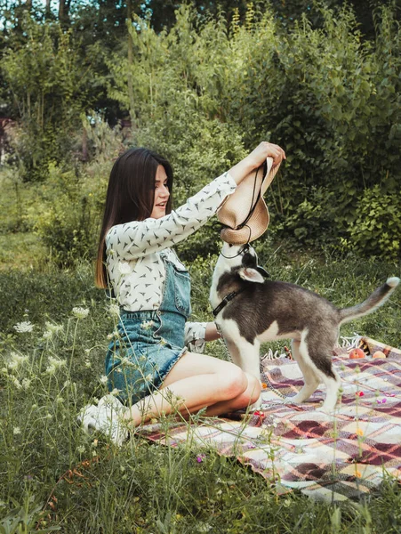 Genç ve güzel kız sevimli köpeğiyle oynuyor. 