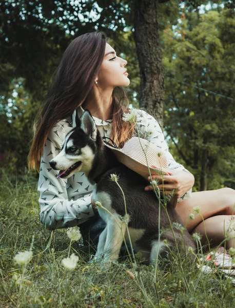 Genç ve güzel kız sevimli köpeğiyle oynuyor. 