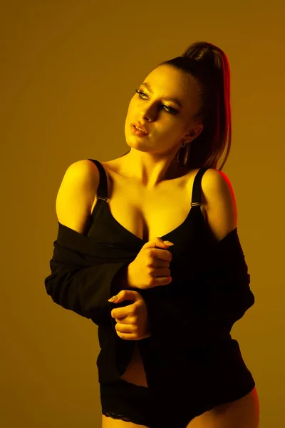 İç çamaşırı ve ceket giyen güzel bir kadın manken.