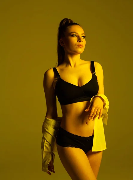 İç çamaşırı ve beyaz gömlek giyen güzel bir kadın manken.