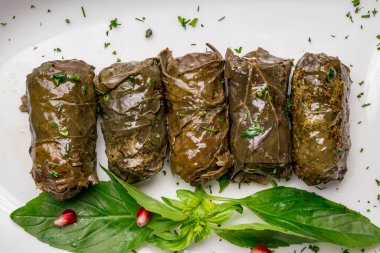 Dolma georgian kitchen with sour cream on white plate on dark table top view macro close up