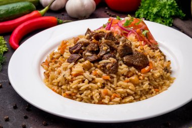 Siyah masada beyaz tabakta sığır eti ve sebze salatası.