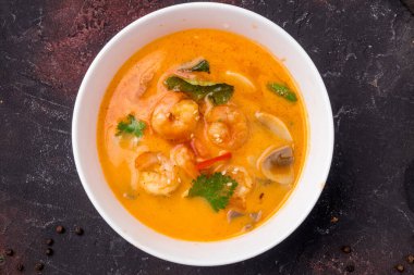 Tom Yam çorbası. Beyaz kâse üzerine karides. Masanın üstünde.