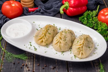 Beyaz tabakta sığır eti ve ekşi krema, Özbek mutfağı.