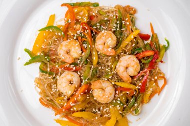 fried Rice noodles with shrimp and vegetables funchosa on dark table top view macro close up