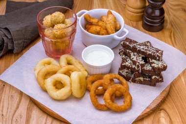 assorted beer snacks on the board with sauce