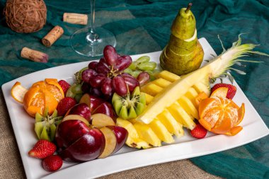 Fruit sliced on a white plate on wooden table