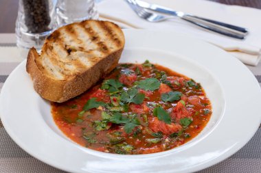 Domates çorbası, yeşillik ve kızarmış ekmek.