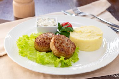 Beyaz tabakta patates püresi ve tavuk pirzolası