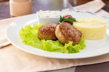 Beyaz tabakta patates püresi ve tavuk pirzolası