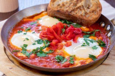 Shakshuka klasiği dökme demir kalemle tahtada