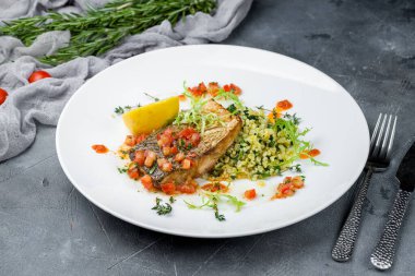 Ispanaklı kızarmış halibut ve gri masada risotto.