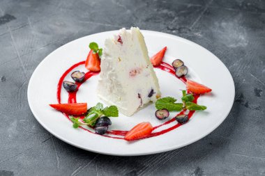 Gri masada çilekli fırında cheesecake.