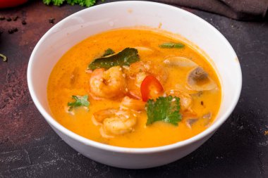 Tom Yam çorbası, siyah masada beyaz kâse üzerinde karides.