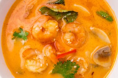 Tom Yam çorbası. Beyaz kâse üzerine karides. Masanın üstünde.
