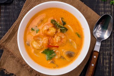 Tom Yam çorbası. Beyaz kâse üzerine karides. Masanın üstünde.