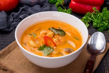 Tom Yam çorbası, siyah masada beyaz kâse üzerinde karides.