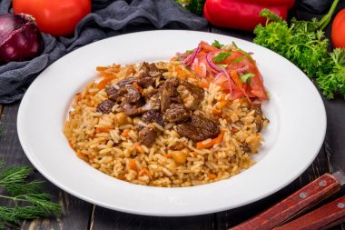 Siyah masada beyaz tabakta sığır eti ve sebze salatası.