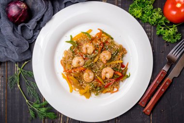 Kızarmış pirinç eriştesi, karides ve sebzeli funchosa. Masanın üstünde.