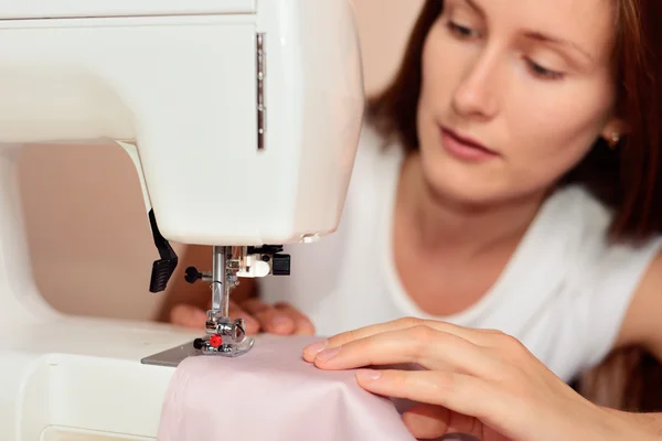 Young attractive woman sewing Stock Photo