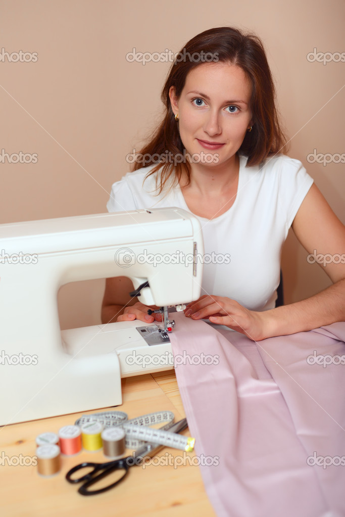 Young attractive woman sewing