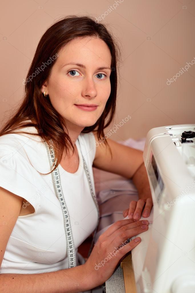 Young attractive woman sewing