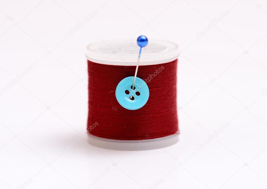Isolated thread spool with pin on white background