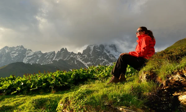 Young woman in red jacket enjoy sunset in mountains — Stock Photo, Image