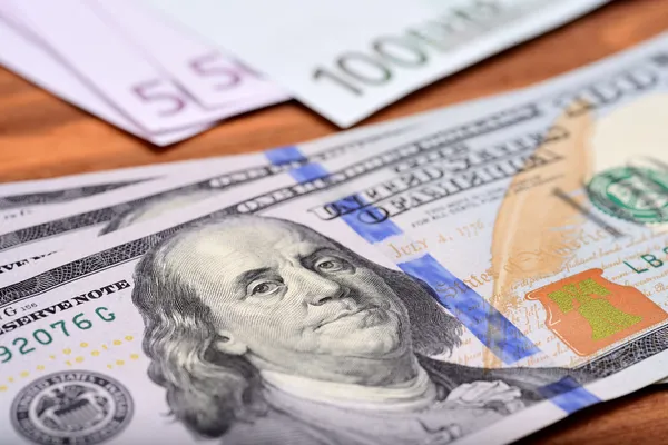 Банкноты доллара и евро на деревянном столе — стоковое фото