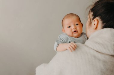 Sevimli küçük kız kucaklaşması heyecanlı genç anne, gülümseyen anne ve komik küçük kız evde eğlenin. Birbirinize yakınlaşın.