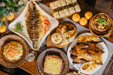 Sovyetler Birliği 'nde masada geleneksel yeni yıl yemeklerini hazırlayan leziz yemeklerle dolu büyük ve cömert bir sofra: etli jöleler, zeytinler, patatesler, fırında tavuk, rendelenmiş yabanturpu, sosis, ezme, votka ve güveç.