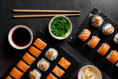 Somon, sos, wasabi, hiashi wakame ve koyu arkaplan.