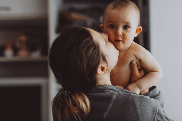 Candid shot of six month old infant baby  standing in the crib holding on to the side