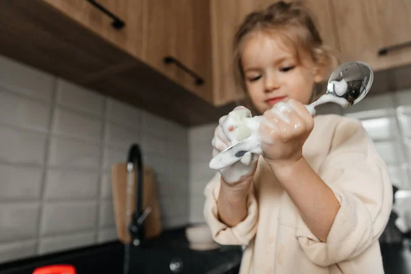 미소짓는 소녀는 집안일을 부엌에서 설거지를 — 스톡 사진