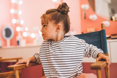 Güzel bir saç stili yaptığı çocuklar için bir güzellik salonunda şık küçük bir kız. Güzellik ve çocuk modası ve sağlıklı saçlar.