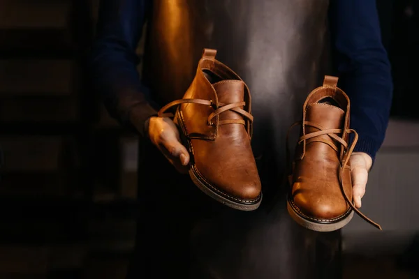 それらを作ったマスターの手に高品質の男性の革の靴のペアの写真 — ストック写真
