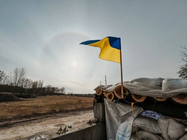 12.03.2022 Irpin, Ukrayna: köyün girişinde otomobilleri kontrol etmek ve sabotajcıları tespit etmek veya düşman araçlarını durdurmak için kendi kendine kurulan kontrol noktası. Ukrayna 'nın sarı ve mavi bayrağı direğin üzerine asıldı.