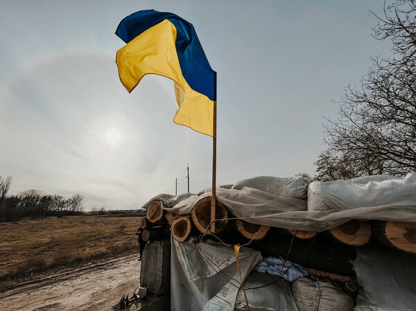 12.03.2022 Irpin, Ukraine: self-made checkpoint at the entrance to the village to check cars and detect saboteurs or stop enemy vehicles. The yellow and blue flag of Ukraine is hoisted over the post