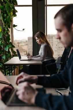 Modern bir ofis bilgisayarında çalışan gençlerin fotoğrafı.