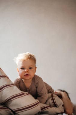 Küçük kız evde giysileriyle yerde oynuyor kitaplar ve oyuncaklar arasında, günlük rutin çocuk.