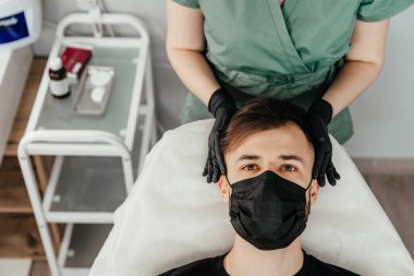 Mesotherapy. Injections with vitamins for hair growth on bald parts of the head in a young man