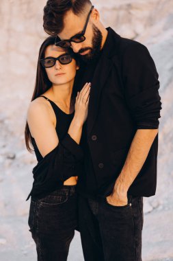 Beyaz dağların arka planında yürüyen ve sarılan şık bir çift. Hoş hippi çift birlikte eğleniyor. Gençlik, aşk ve yaşam tarzı kavramı. İlkbahar.