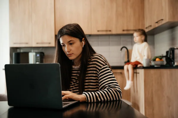 Freiberuflerin Sitzt Tisch Heimischen Küchenbüro Und Arbeitet Laptop Verspieltes Kind — Stockfoto